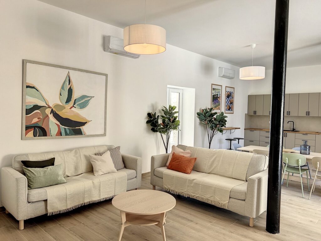 Salon lumineux avec deux canapés, une table basse ronde et un grand tableau